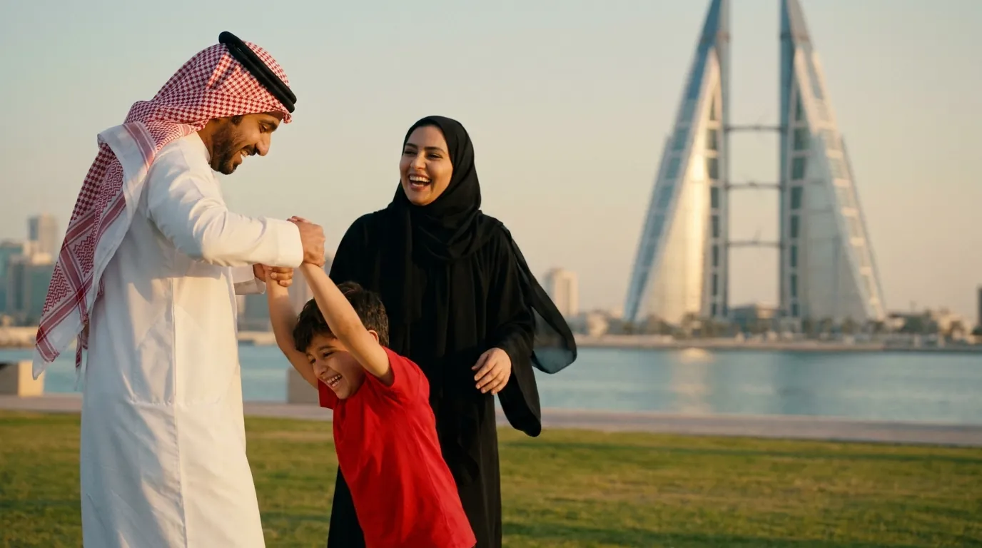 أب يلاعب ابنه على العشب عند خليج البحرين، والأم تضحك بجانبهما.