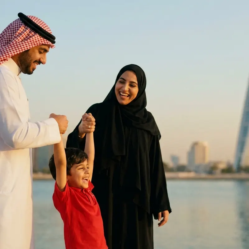 أب يلاعب ابنه والأم تضحك عند البحر.